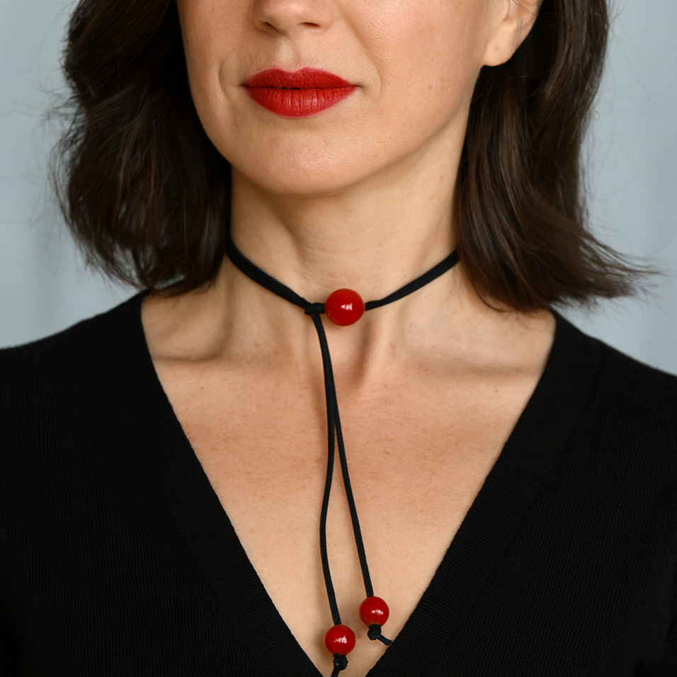 Red beads on black suede necklace.