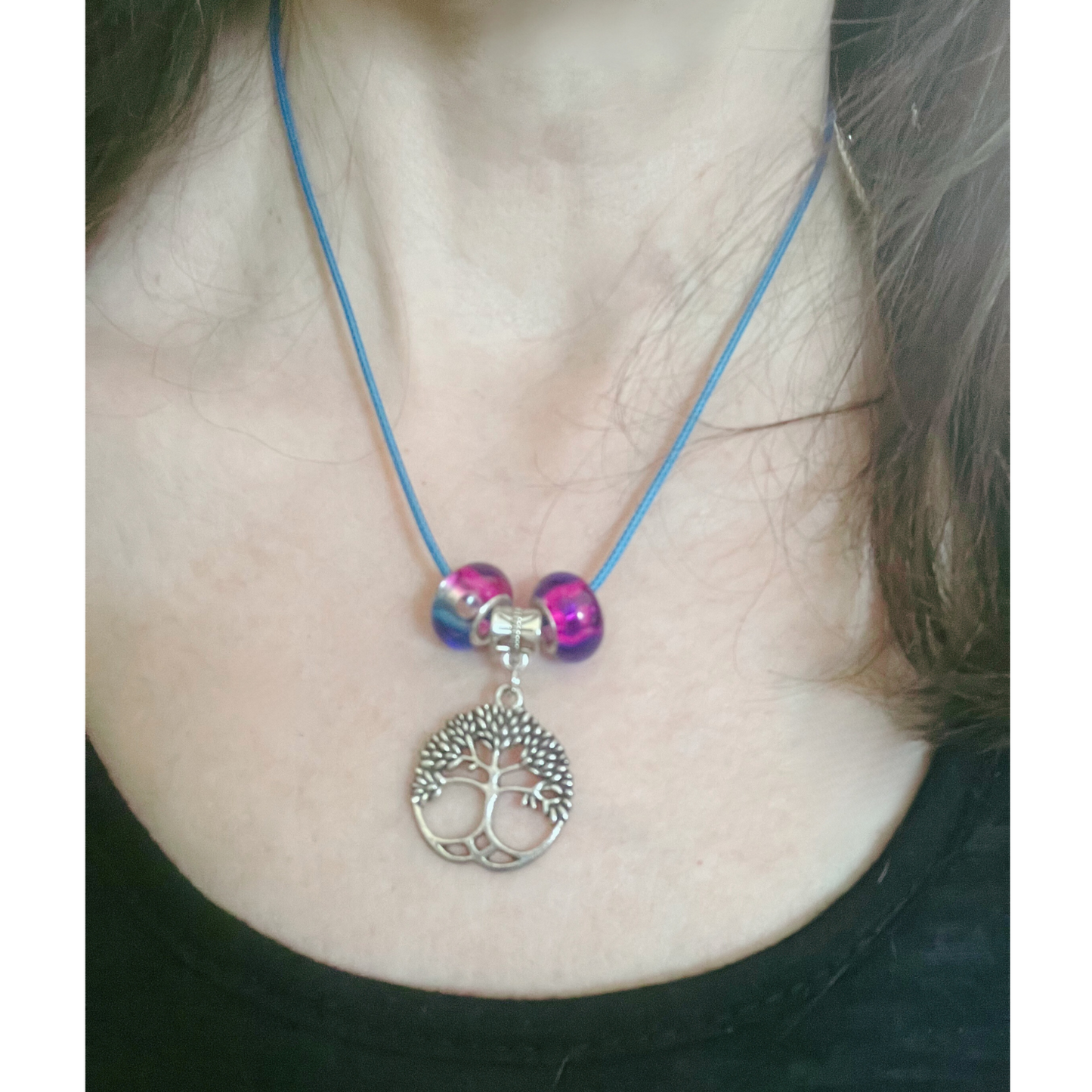 Blue cord necklace with purple and blue glass beads and silver tree pendant.