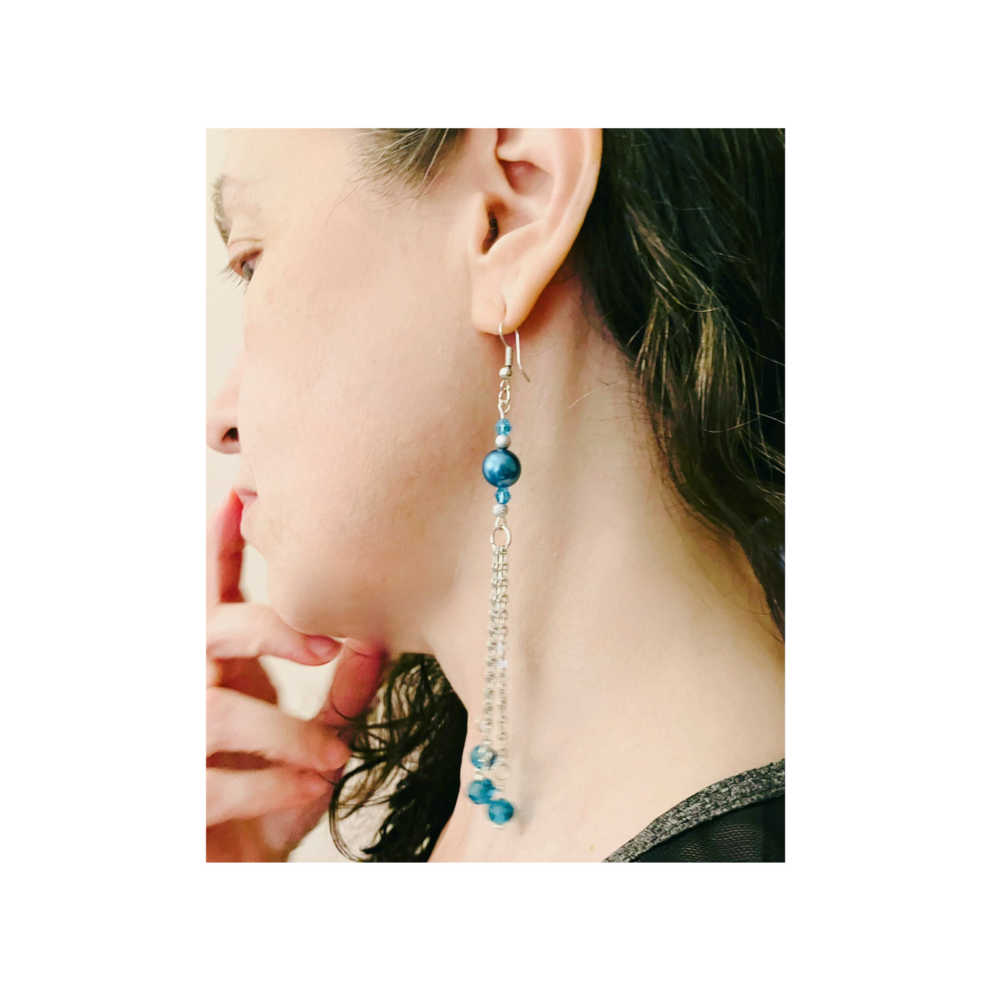 Silver dangling earrings with blue pearls and beads.