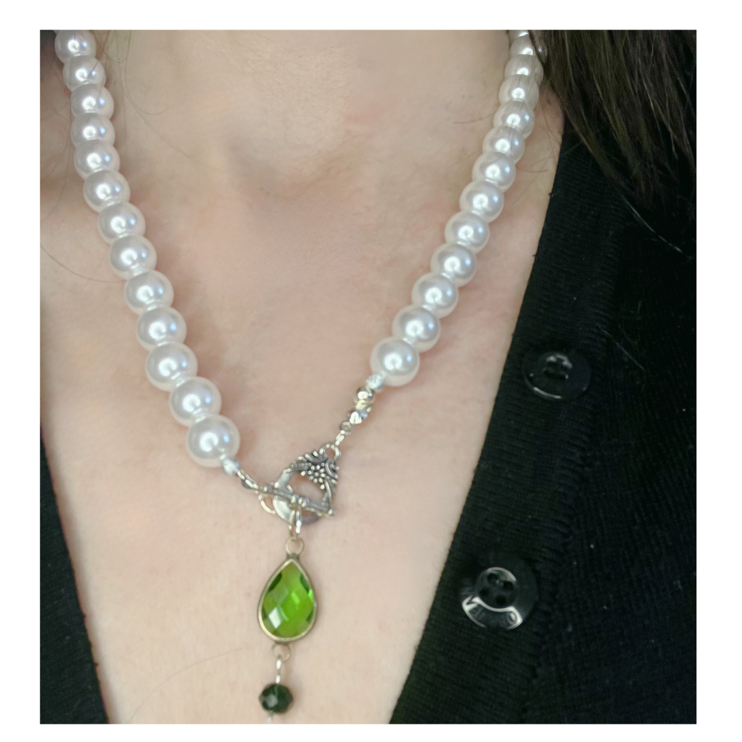 Pearl necklace with green bead pendant.