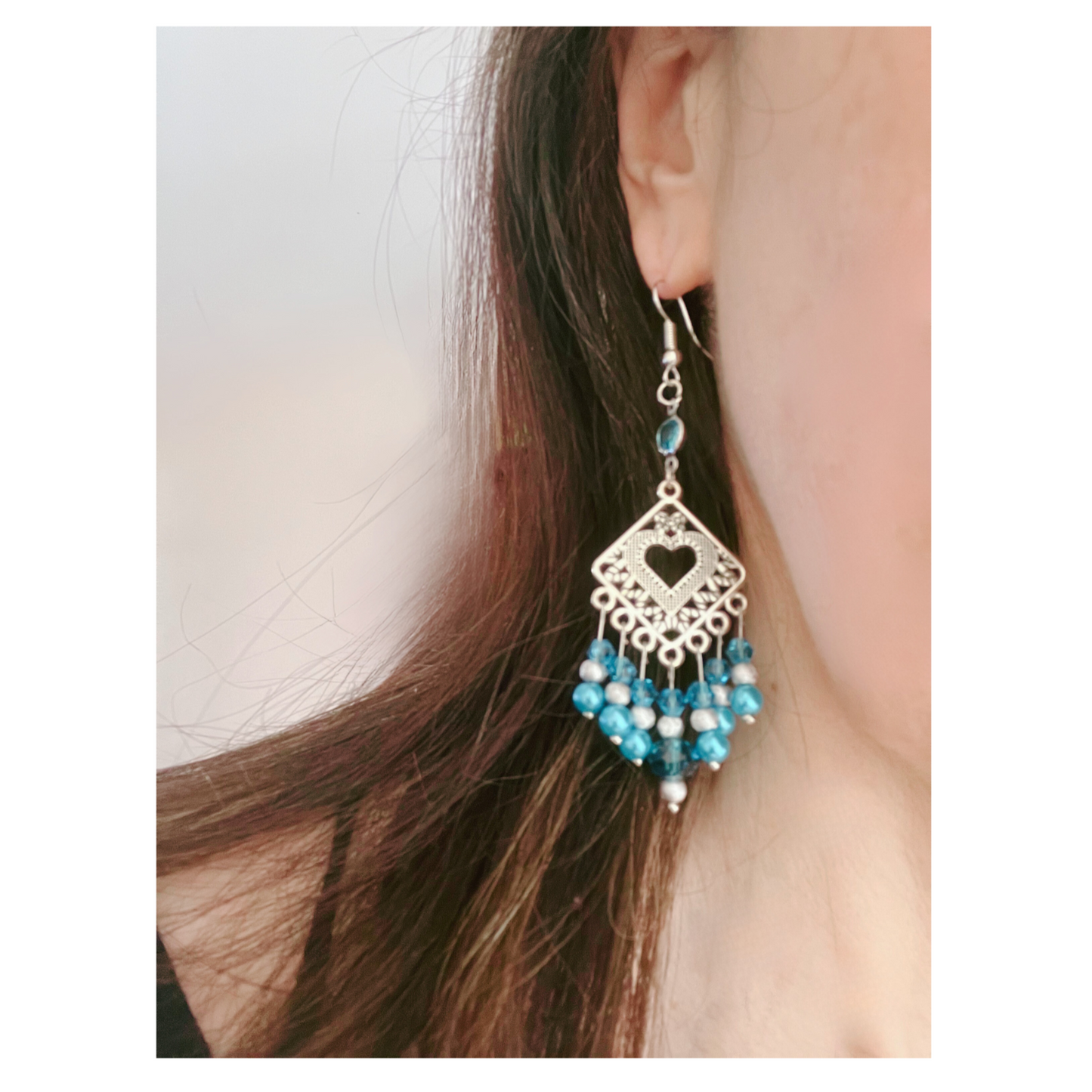 Silver dangling earrings with blue beads.