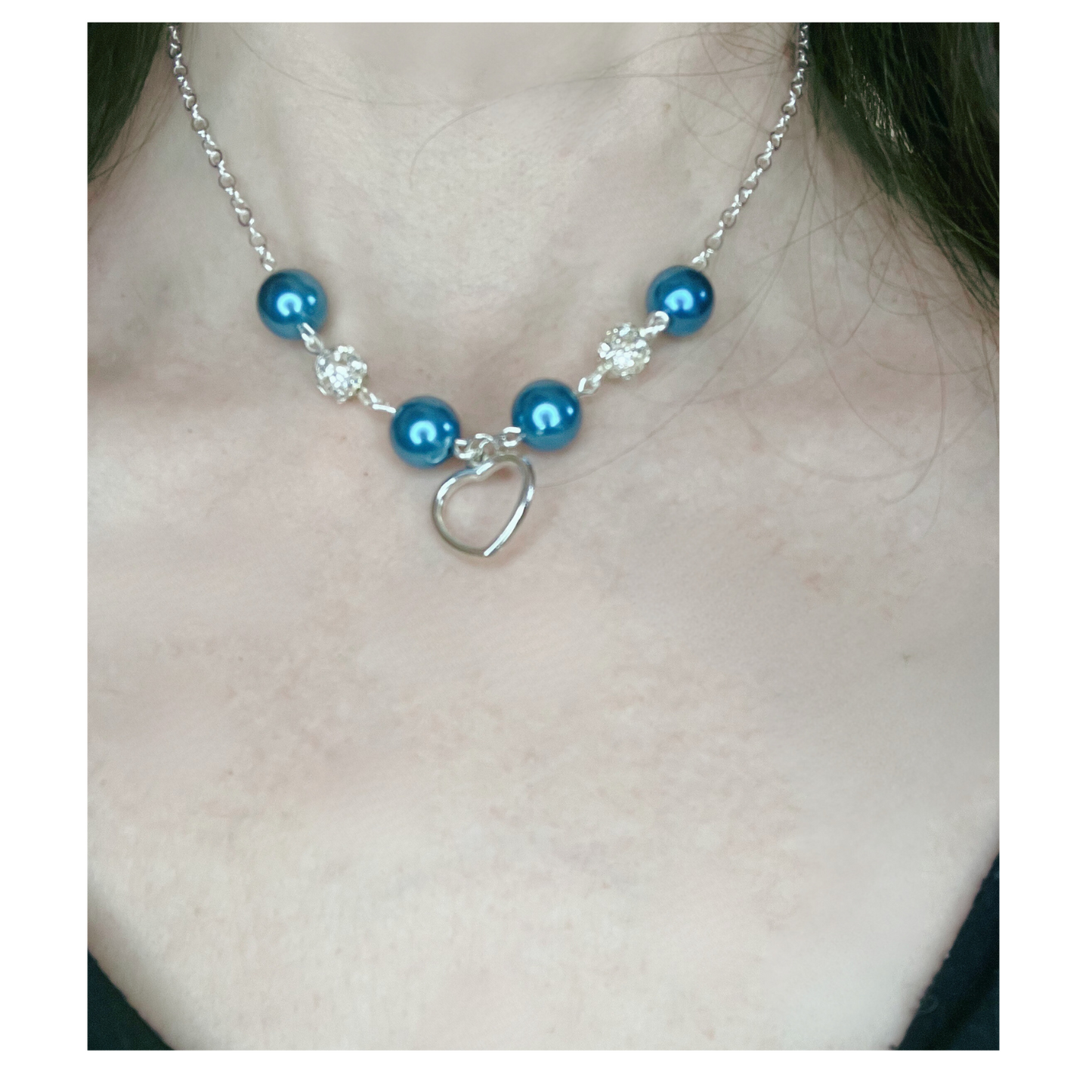 Silver necklace with blue and silver beads with heart pendant.