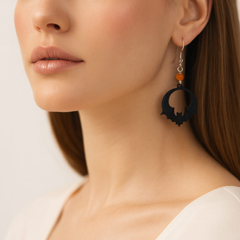 Halloween themed black bat earrings with orange beads.