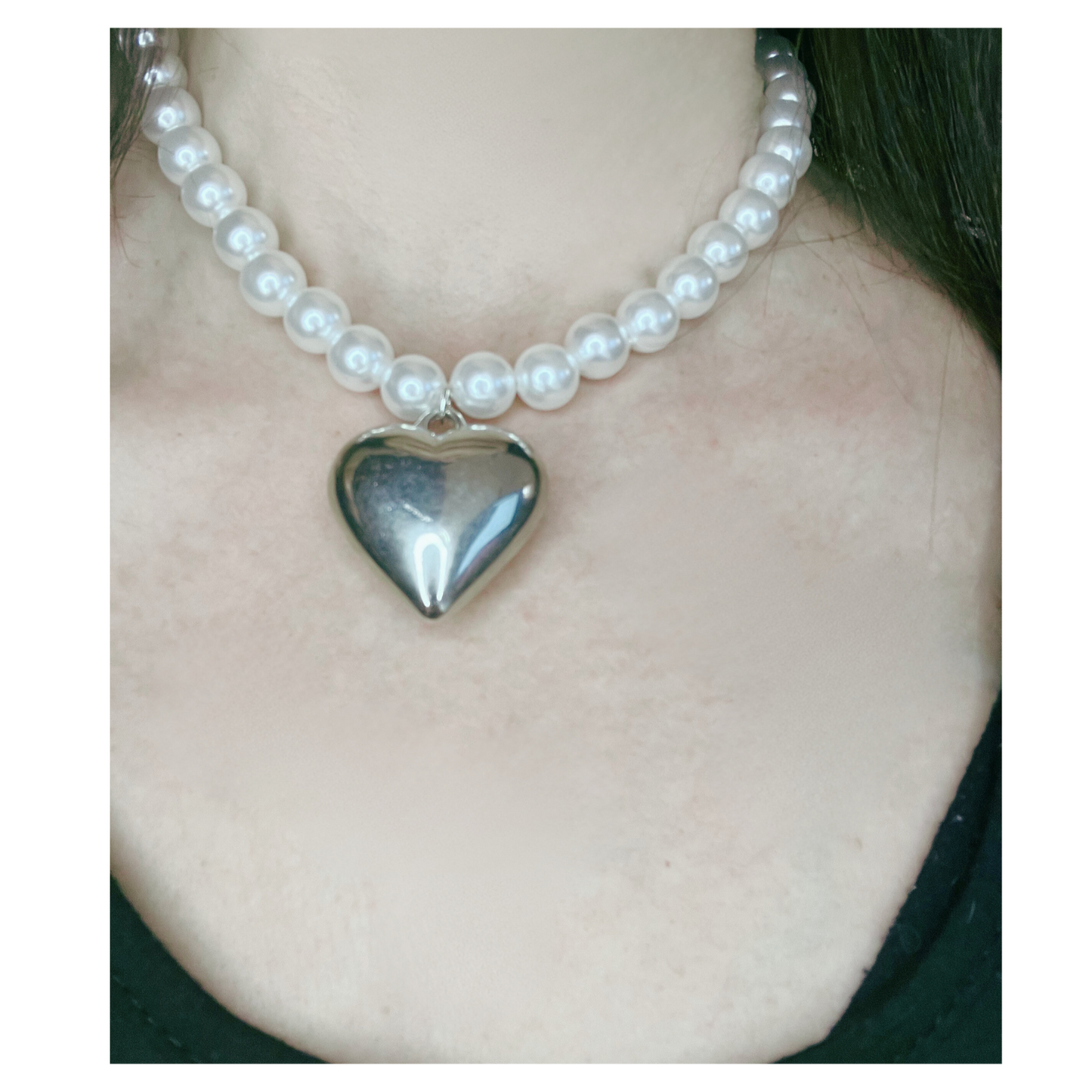 Pearl necklace with a silver heart pendant.