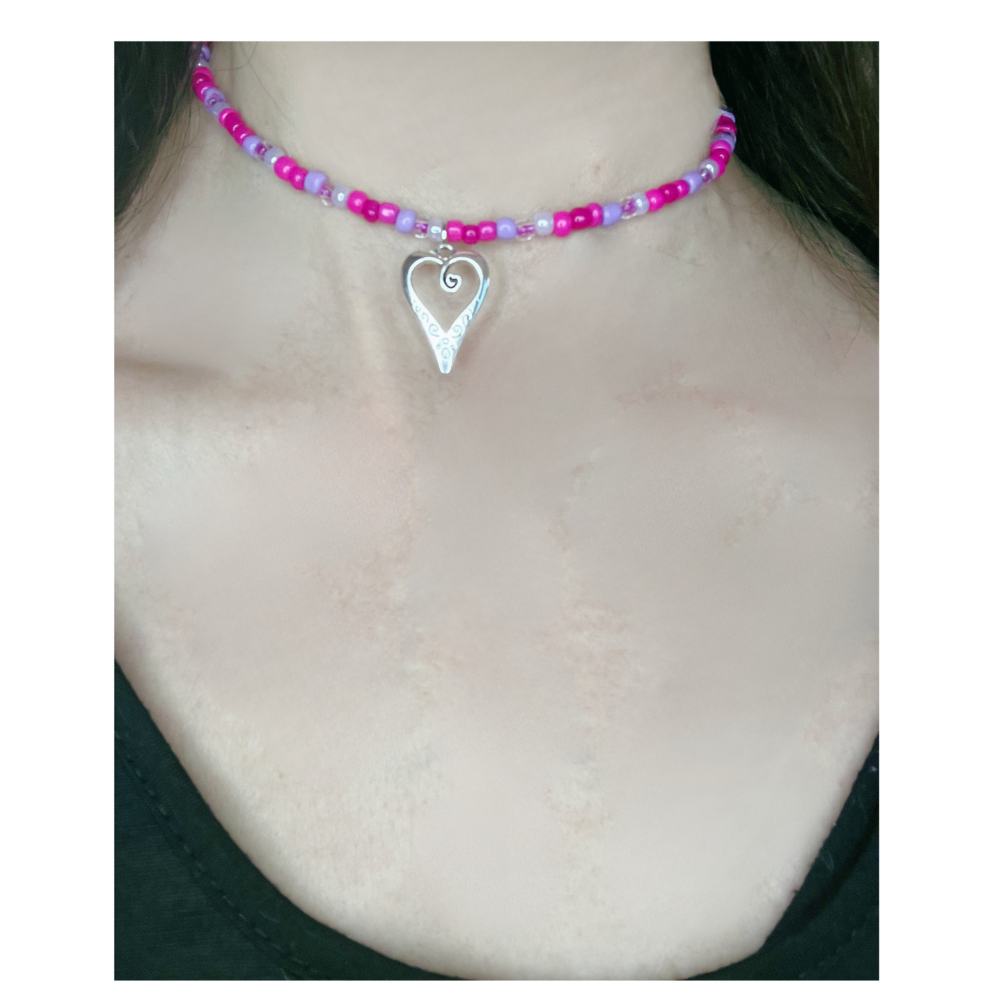 Necklace with pink beads and a silver heart pendant.