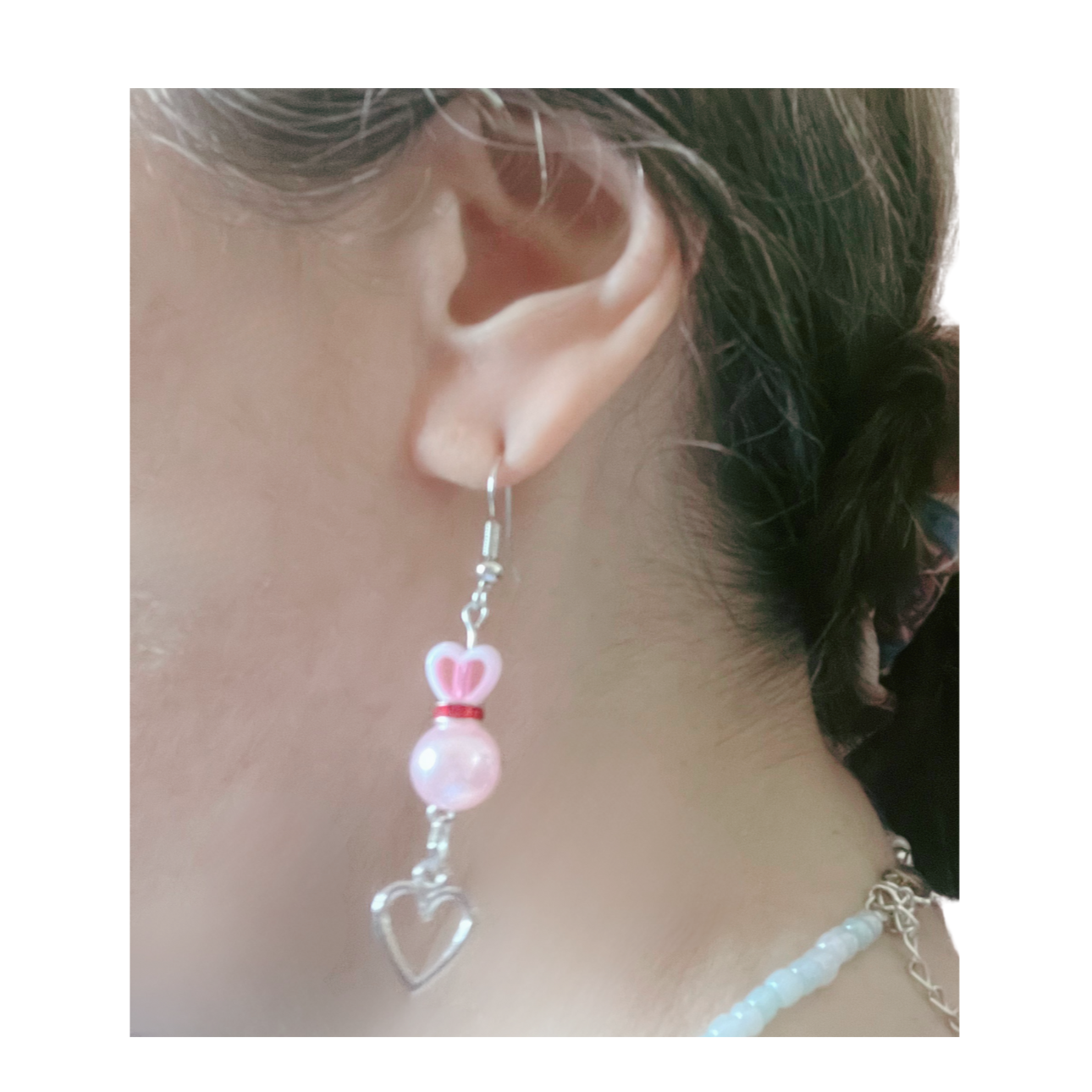 Close-up of the heart-shaped earring with pink beads.