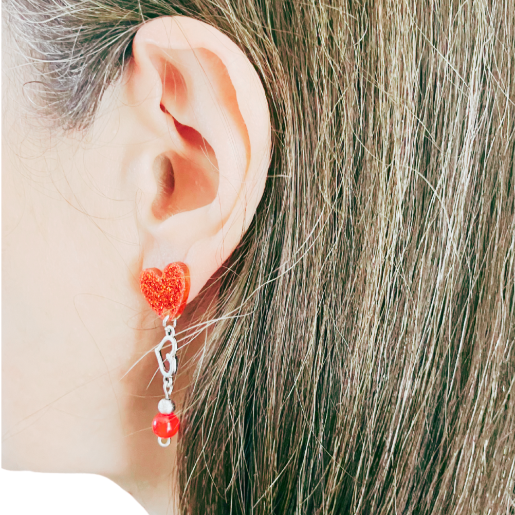 Dangling red heart earrings.