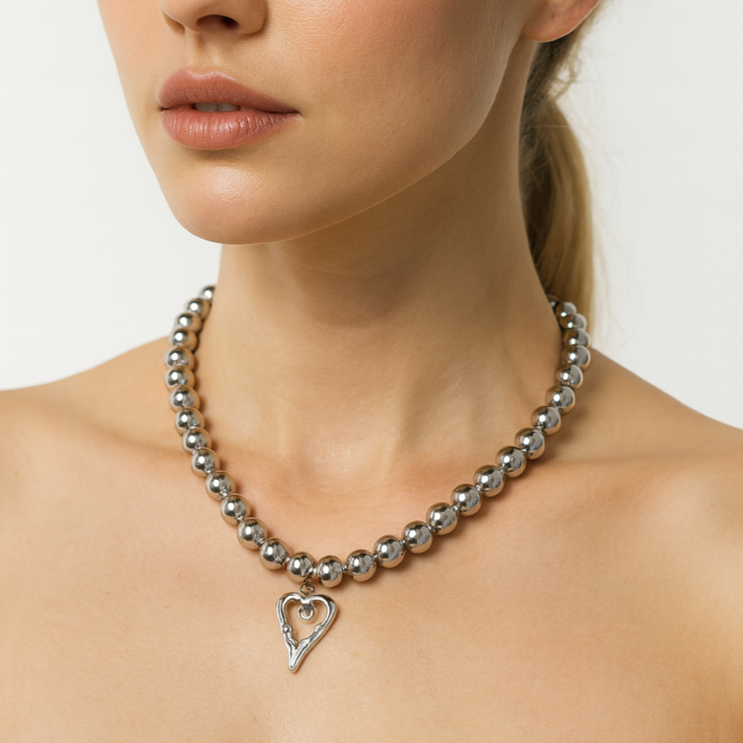 Silver beads necklace with a heart pendant.