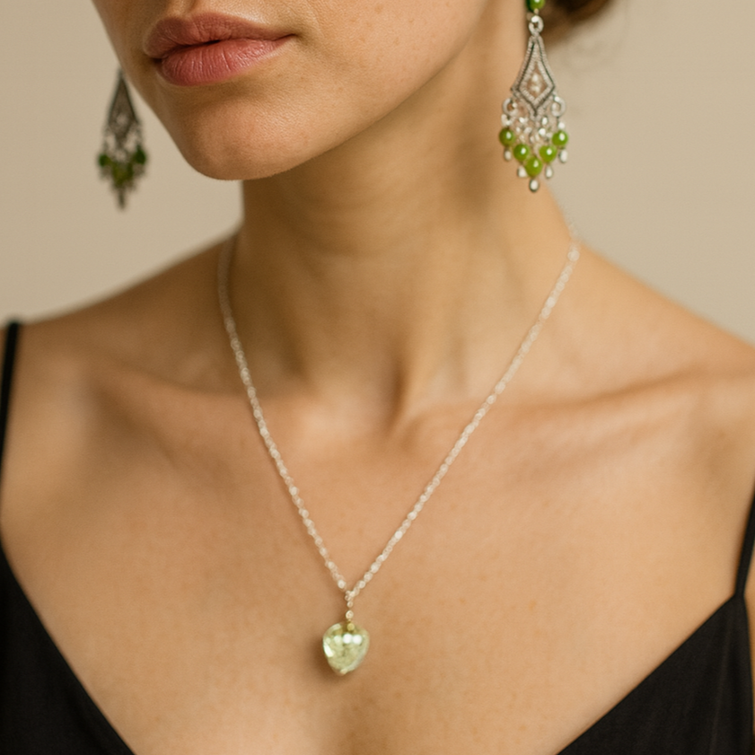 Silver necklace with green heart pendant.