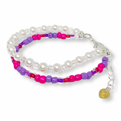 Beaded bracelet with white pearls, pink, purple, and red beads.