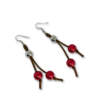 Black suede dangling earrings with silver and red beads.
Brincos cordão de camurça com missangas vermelhas.