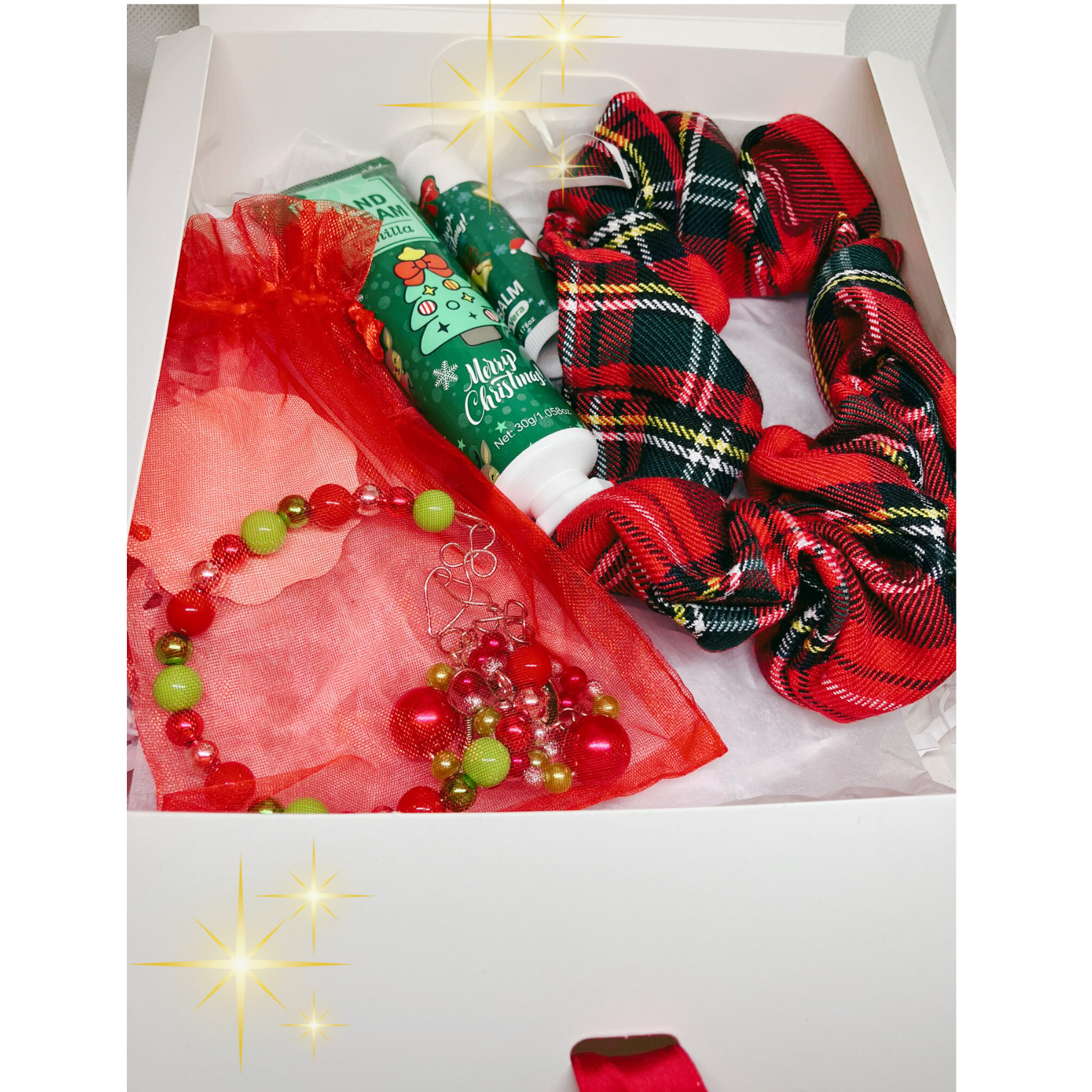 Christmas-themed gift set with red plaid scrunchie, vanilla hand cream and lip balm, earrings and bracelet.