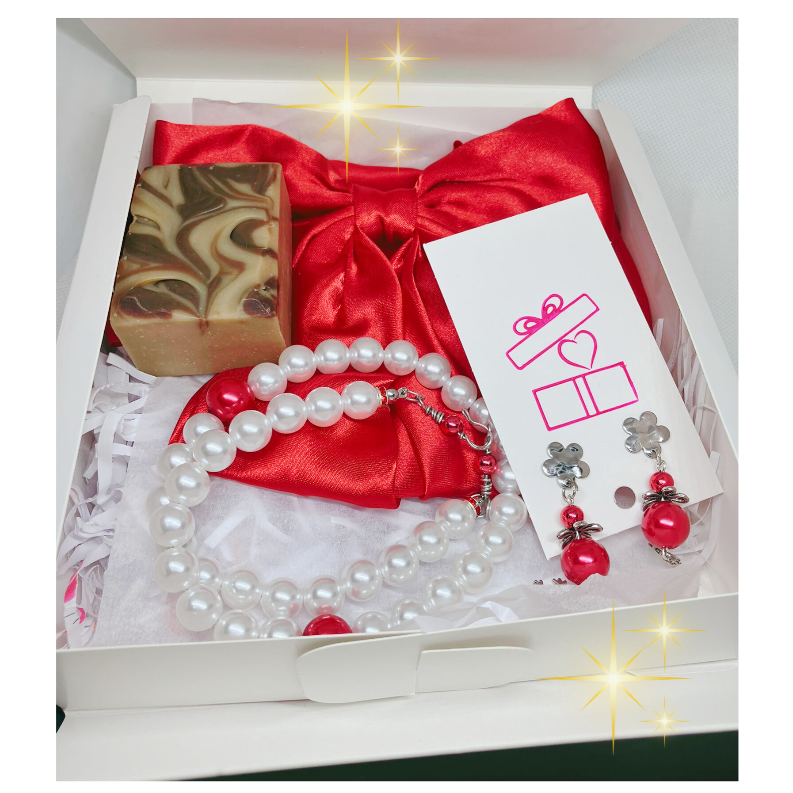 Gift set with red satin bow, pearl necklace, earrings, and soap in a box.