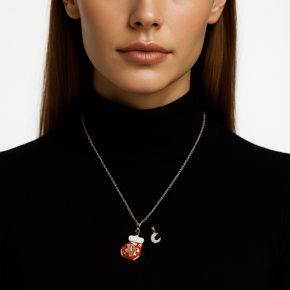 Silver necklace with gingerbread man pendant and extra pink moon pendant.