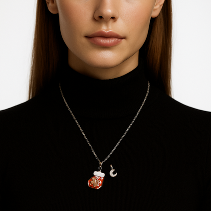 Silver necklace with gingerbread man pendant and extra pink moon pendant.
