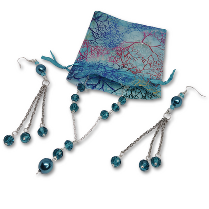 The Everyday Elegance gift set for women featuring silver necklace with blue pearls and matching earrings inside a cute organza gift bag.