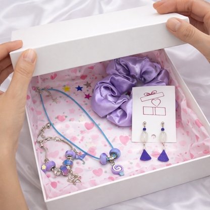 Set of purple jewelry including a scrunchie, necklace, and earrings in a gift box.