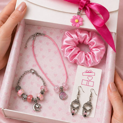 Set of jewelry including a bracelet, earrings, and scrunchie in a gift box with a pink ribbon.