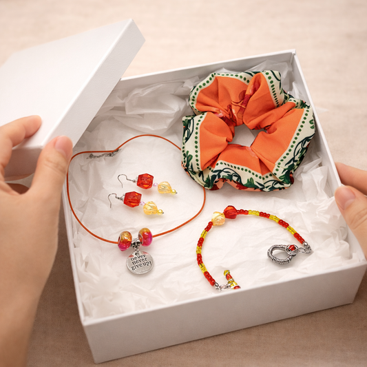 Set of jewelry including a scrunchie, necklace, and earrings in a white box.