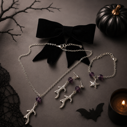 A gothic jewelry set featuring a silver branch necklace, matching star and branch drop earrings, and a bracelet, styled with a black velvet bow.