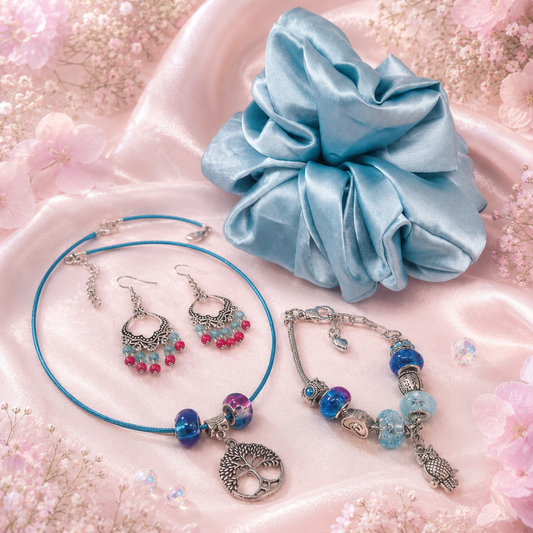 ✨ Set Includes:

A Tree of Life charm necklace on a soft blue choker

A matching blue and silver charm bracelet with gorgeous glass beads

Bold boho-style dangle earrings with hot pink and aqua beads

A luxurious oversized satin scrunchie in an ocean blue hue