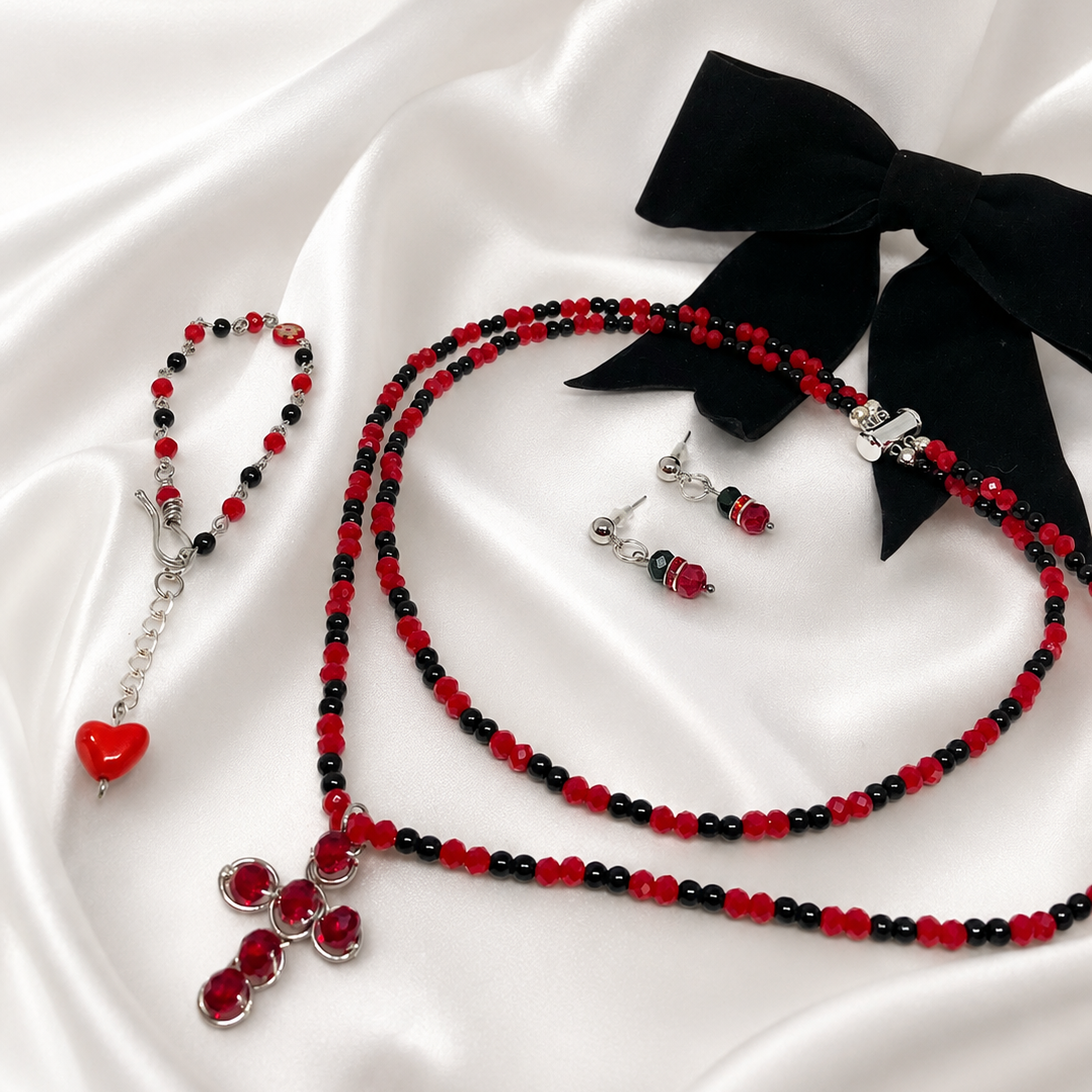 Set of jewelry including a necklace, earrings, bracelet and black velvet hair bow inside gift box.