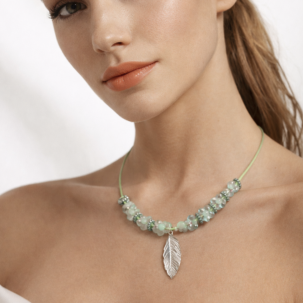 Green rope necklace with turquoise beads and leaf pendant.