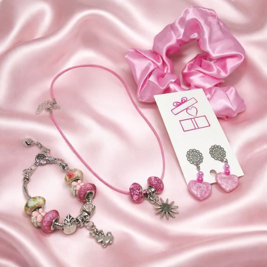 Gift set consists of necklace, matching charm bracelet, resin hearts earrings and pink satin hair scrunchie.