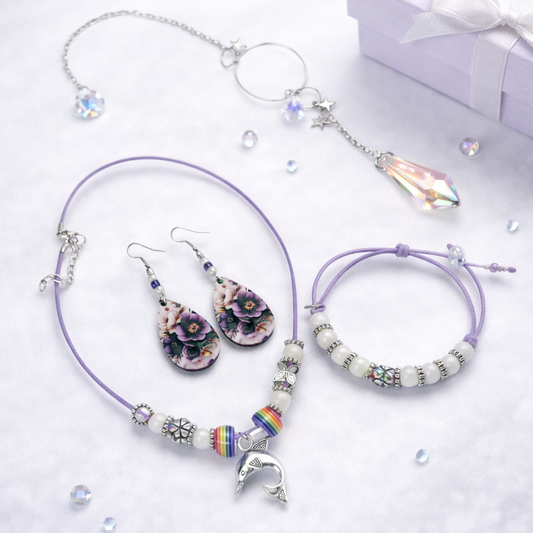 Gift set includes, purple rope necklace with beads and dolphin pendant, matching bracelet, dangling flower earrings and sun catcher.