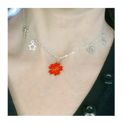 Silver necklace with red flower and charms.