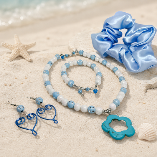 Gift set includes, necklace with white and blue beads, flower pendant, matching bracelet, heart earrings and blue satin hair scrunchie.