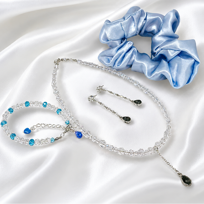 This set includes, necklace with glass beads, matching bracelet, earrings and satin hair scrunchie.