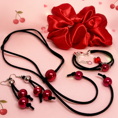 Serene Glow gift set for women, feature red satin scrunchie for hair, black suede cord with red beads, matching dangling earrings.
Packed in gift box.