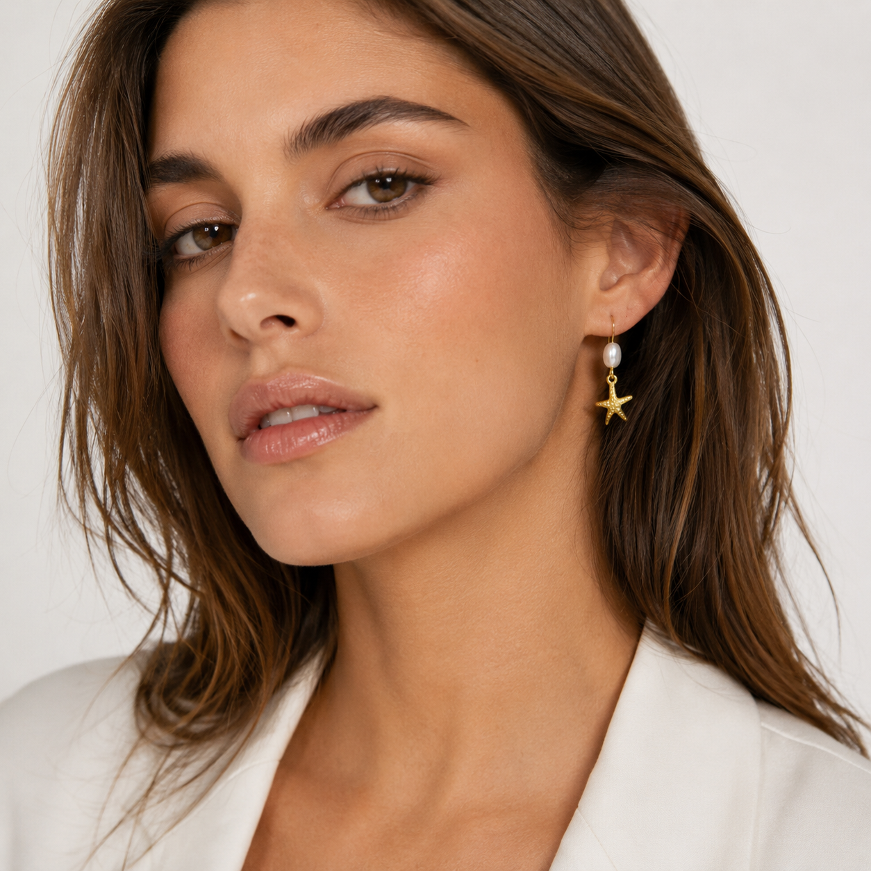 Gold starfish earrings and white pearl