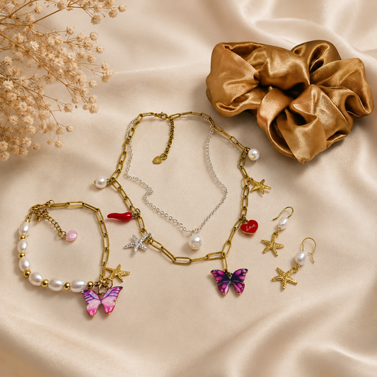 Stack necklace imitation gold chain necklace with multiple charms (including a butterfly, chili, star, and pearl) and silver necklace with pearl pendant.
Matching bracelet and earrings.
Gold satin hair scrunchie