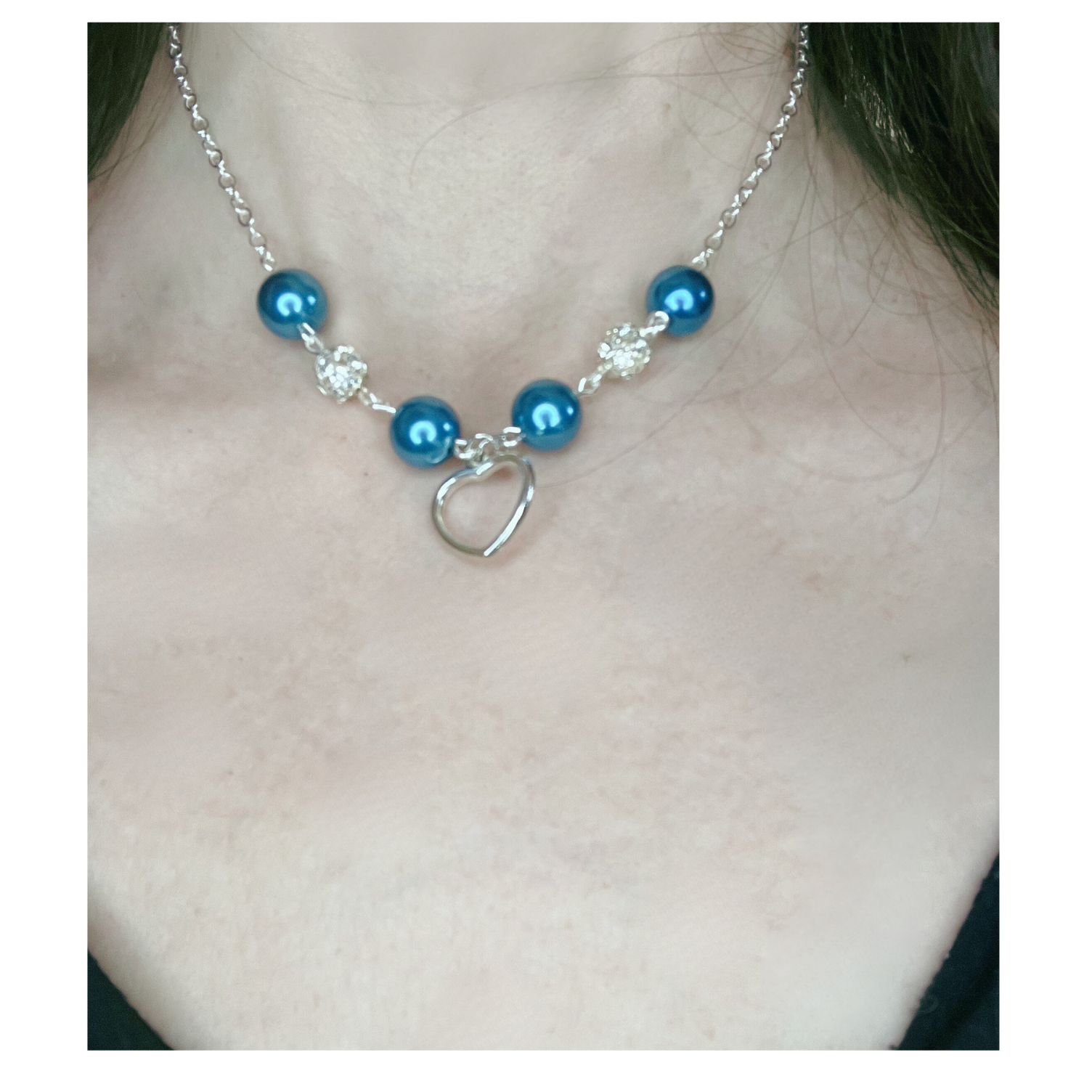 Silver necklace with blue and silver beads with heart pendant.