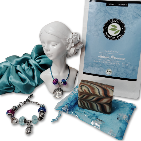 A luxurious jewelry gift set for women, featuring a charm bracelet, pendant necklace, organic herbal tea, artisan soap, satin scrunchie, and organza pouch. Perfect for self-care and relaxation.