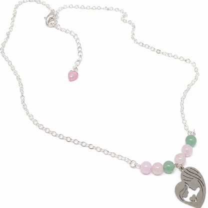 A silver chain necklace featuring a heart-shaped pendant with a mother-and-child silhouette, accented by pink and green beads.