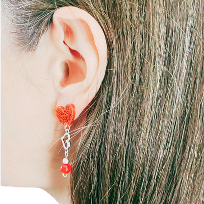 Dangling red heart earrings.