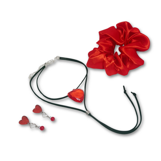 A striking trio crafted for the bold and romantic soul. This gift-ready combo includes a fiery red satin scrunchie, a layered black cord choker with a statement red heart pendant, and matching dangle earrings featuring shimmering red hearts and delicate silver accents. Whether you're dressing up for date night or gifting a touch of love, this set adds a perfect pop of passion and charm.