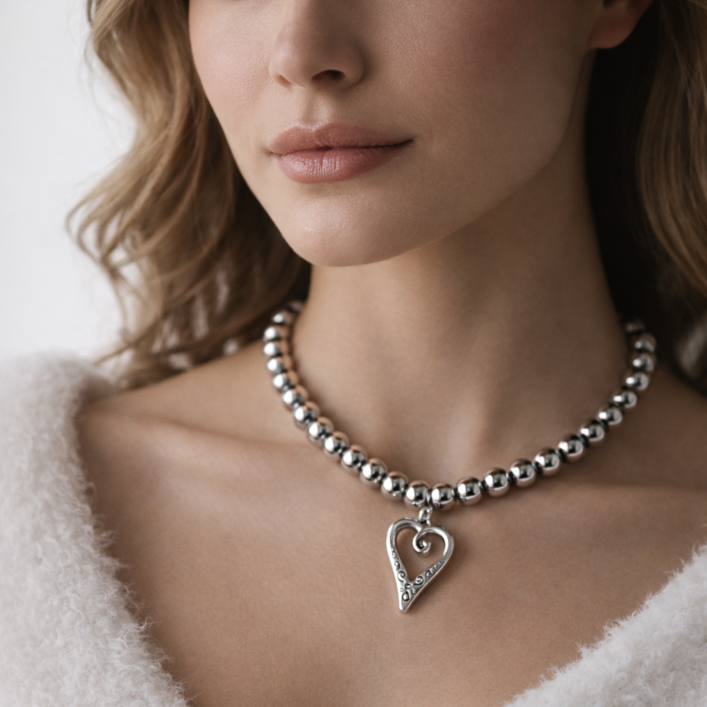 Silver beads necklace with heart pendant.