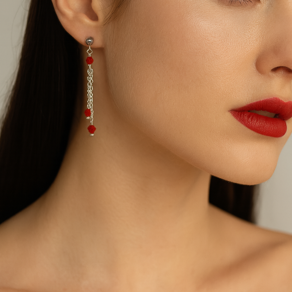 Silver dangling earrings with red beads.