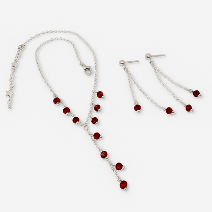 Silver necklace and earrings with red beads.