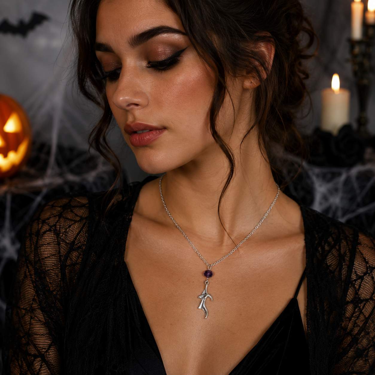  Silver-toned necklace with a small bat pendant and a dark purple bead.