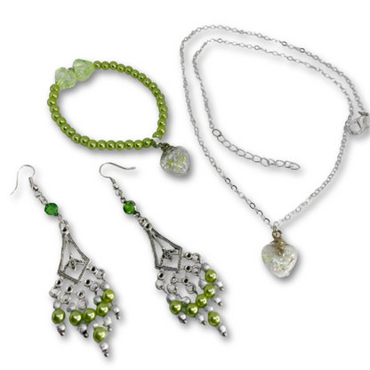 Verdant Glow gift set features silver necklace with heart, dangling earrings, and matching bracelet.