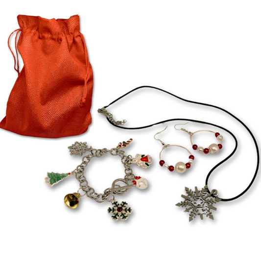 A Christmas set of jewelry charm bracelet, snowflake pendant necklace and beaded earrings red and silver. Presented in a red gift bag.